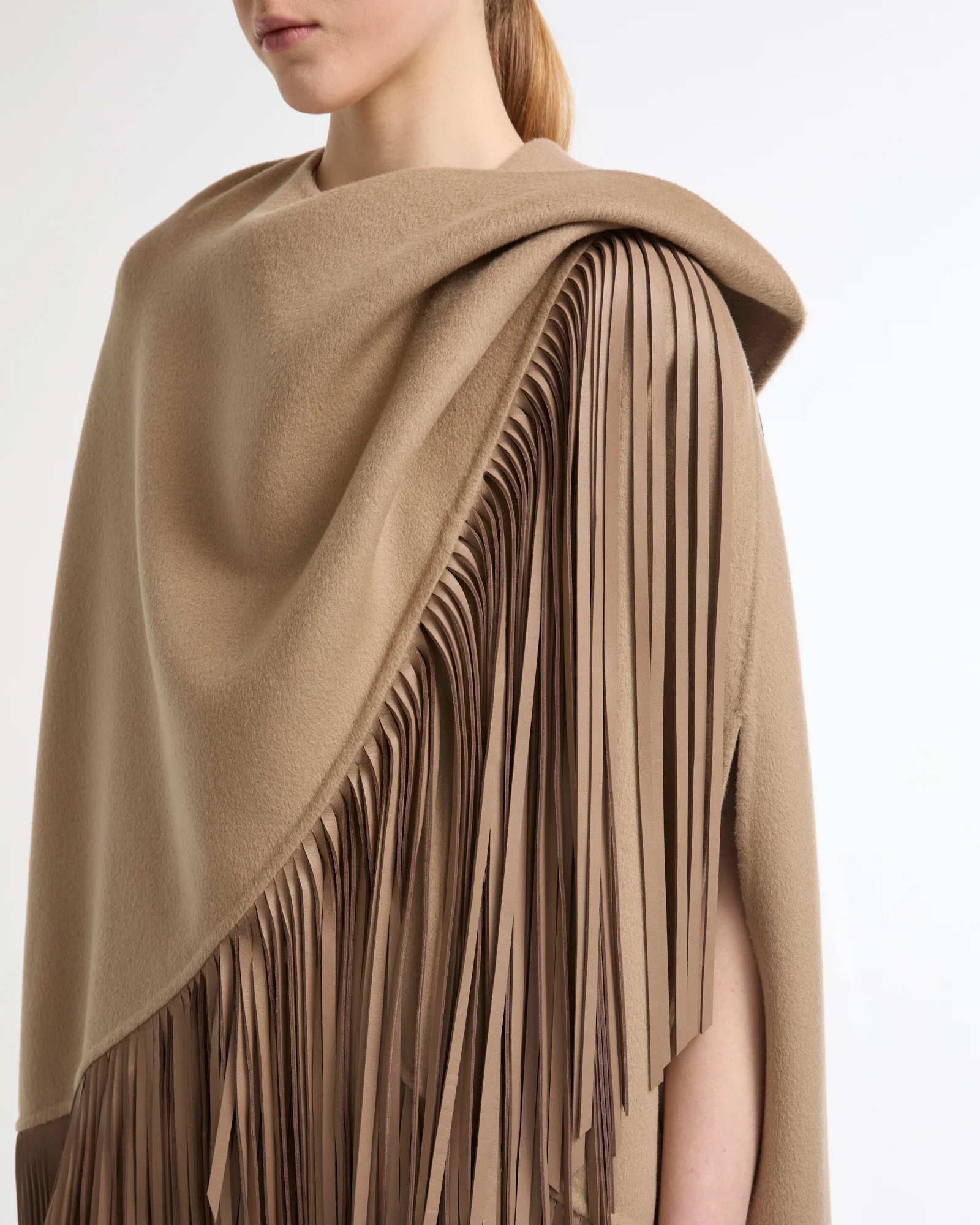 Cape courte asymétrique en lainage cachemire et franges en cuir
